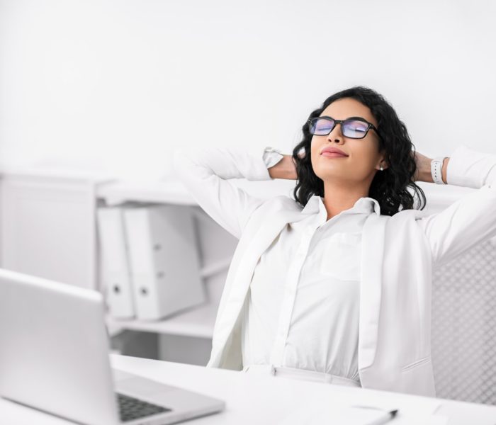 Hispanic businesswoman in glasses relaxing at work