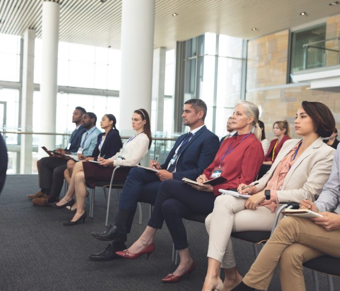 Side view of diverse well dressed business people attending a business seminar in office building