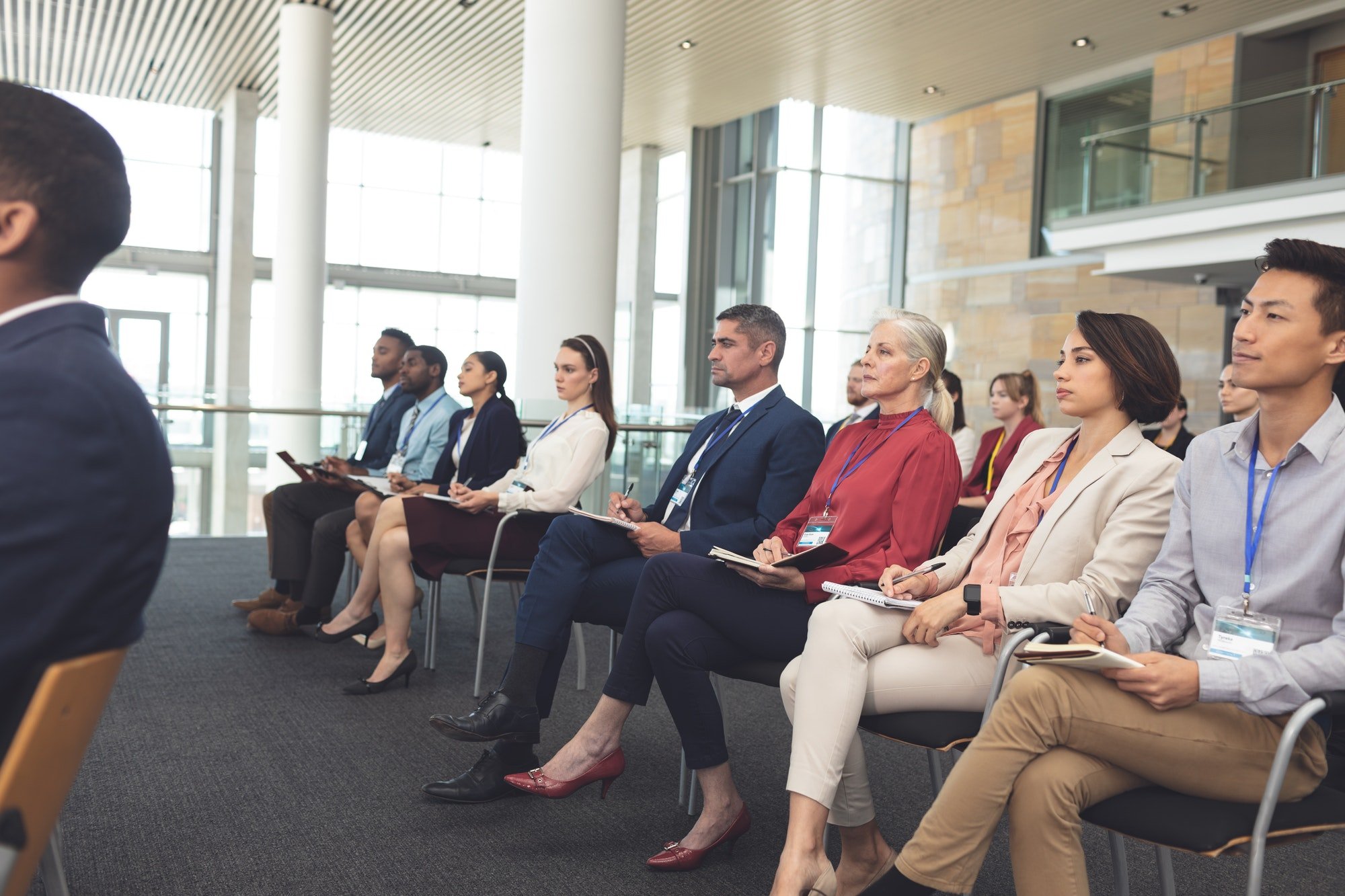 Side view of diverse well dressed business people attending a business seminar in office building